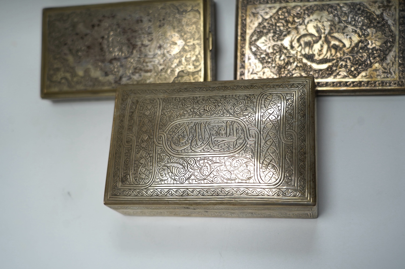 An Egyptian white metal cigarette box, 14,5cm, a Persian white metal cigarette box and similar cigarette case, gross weight 26.6oz. Condition - poor to fair